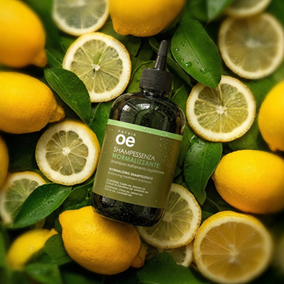 immagine del prodotto dello shampoo normalizzante ambientato su sfondo con limoni e foglie verdi 